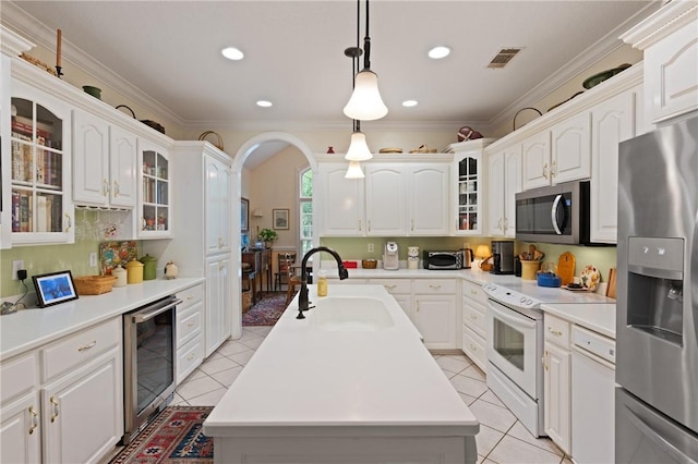 117 Serenoa Dr, Brunswick, GA 31523 - kitchen with stainless steel appliances, beverage cooler, a center island with sink, light tile patterned flooring, and recessed lighting