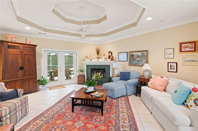 117 Serenoa Dr, Brunswick, GA 31523 - living area with light tile patterned floors, ceiling fan, a tray ceiling, ornamental molding, and a lit fireplace