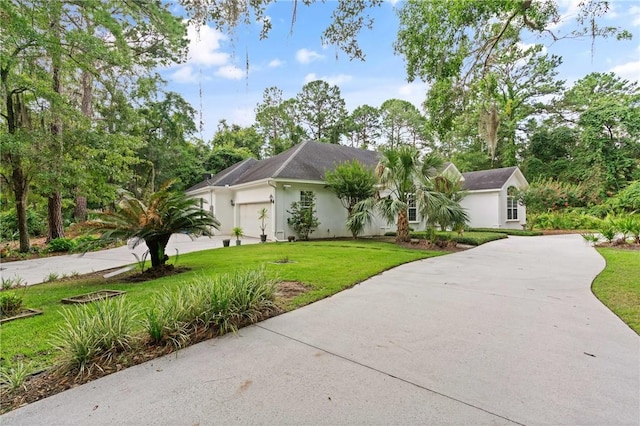 117 Serenoa Dr, Brunswick, GA 31523 - view of front of house featuring driveway, a front yard, stucco siding, and an attached garage
