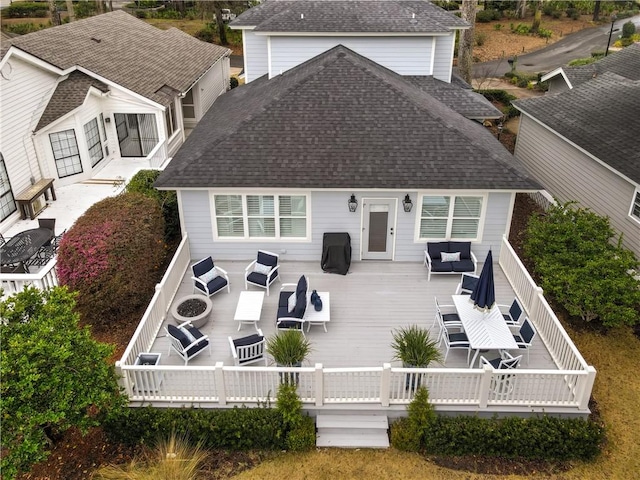 back of property featuring outdoor dining space, a wooden deck, a shingled roof, and an outdoor hangout area