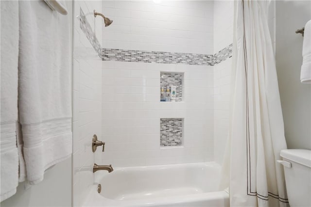 bathroom featuring shower / bath combination with curtain and toilet