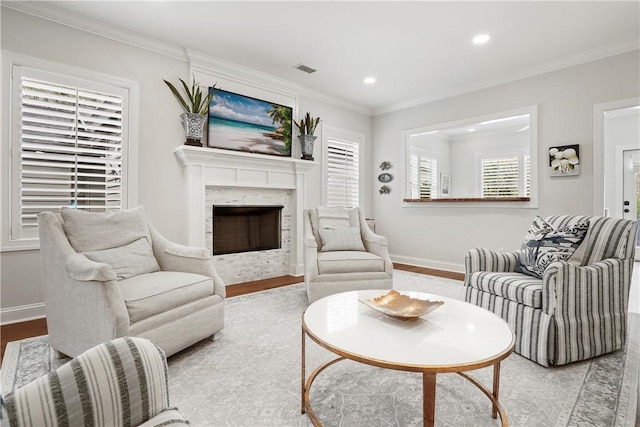 living area with baseboards, ornamental molding, recessed lighting, a fireplace, and wood finished floors