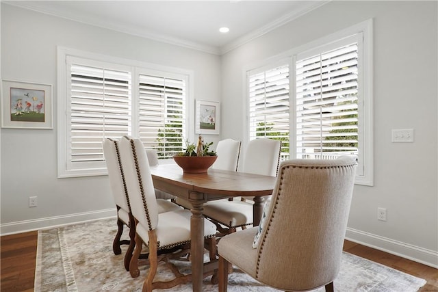 dining area with a wealth of natural light, crown molding, baseboards, and wood finished floors