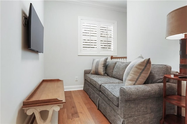 living room with wood finished floors, baseboards, and ornamental molding