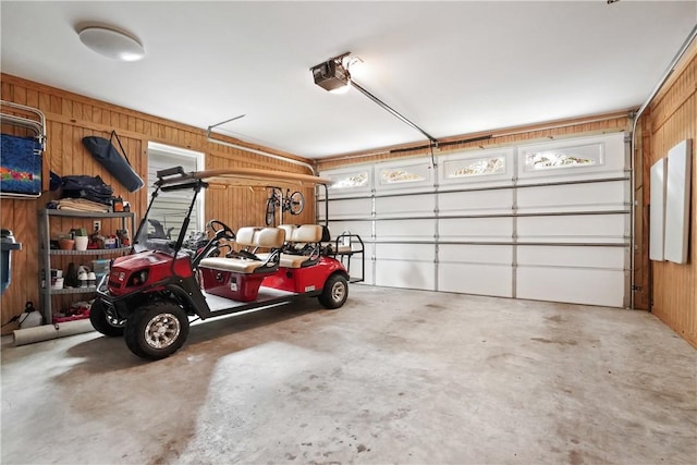 garage with wood walls and a garage door opener