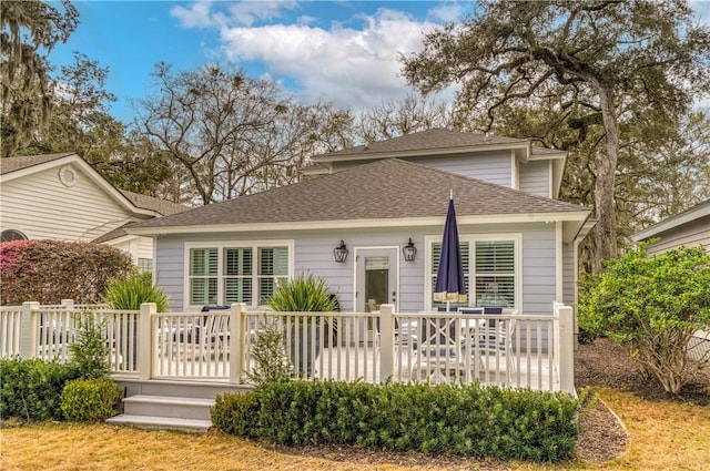 back of house featuring a wooden deck and a shingled roof