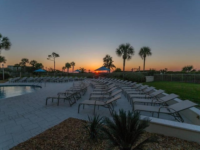 pool at dusk with a patio