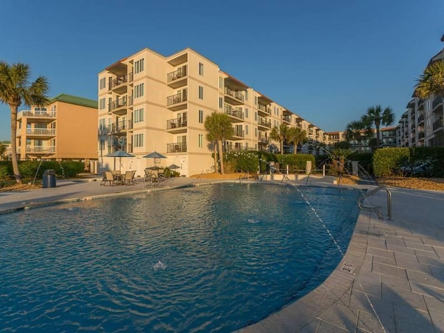 view of swimming pool with pool water feature and a patio