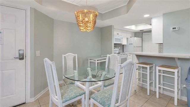 tiled dining room featuring a notable chandelier and a tray ceiling