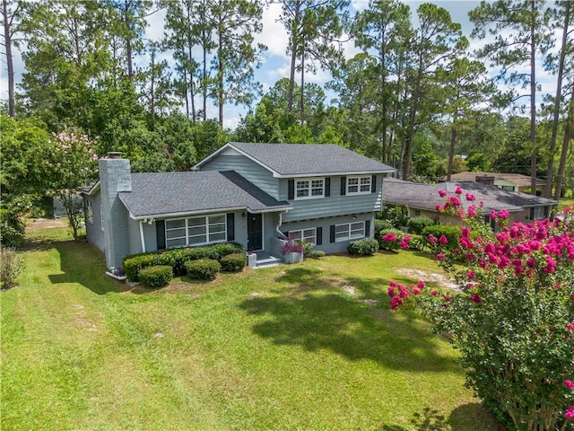1007 Atlantic Ave, Waycross, GA 31501 - tri-level home with a chimney, a front yard, and view of scattered trees