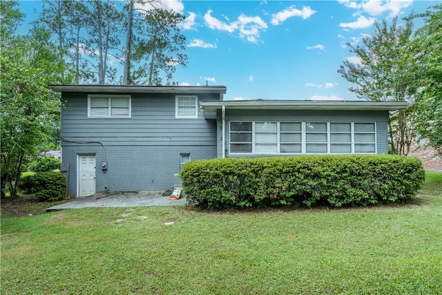 1007 Atlantic Ave, Waycross, GA 31501 - rear view of house with a yard, a patio area, and brick siding