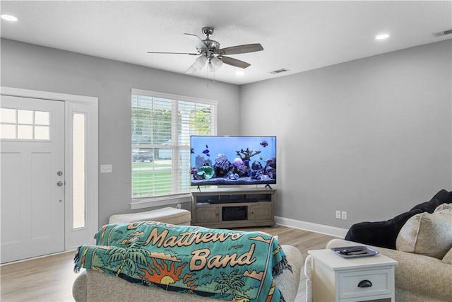 living room featuring light hardwood / wood-style flooring and ceiling fan