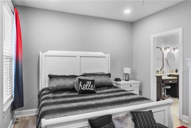 bedroom with ensuite bath and light hardwood / wood-style flooring