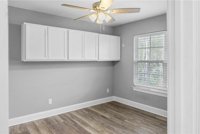 empty room with hardwood / wood-style floors, ceiling fan, and a healthy amount of sunlight