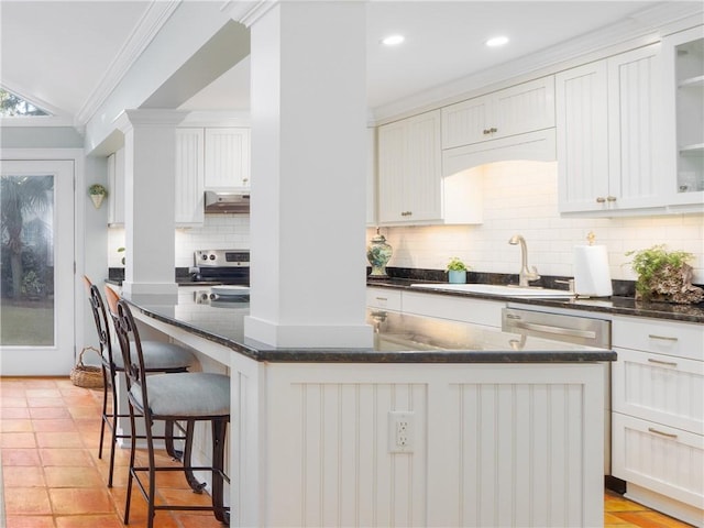 kitchen with white cabinetry, a breakfast bar, a center island, and sink