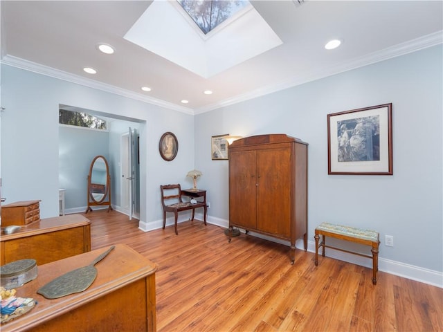 living area with ornamental molding, light wood-type flooring, and a skylight