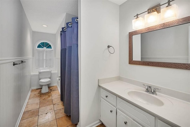 bathroom with a shower with shower curtain, a textured ceiling, vanity, and toilet