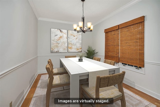 dining space with a notable chandelier, light wood-type flooring, and crown molding