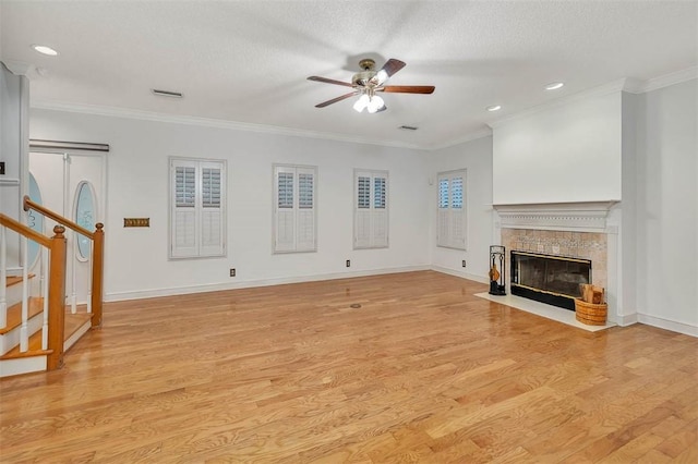 unfurnished living room with ceiling fan, light hardwood / wood-style flooring, a high end fireplace, crown molding, and a textured ceiling