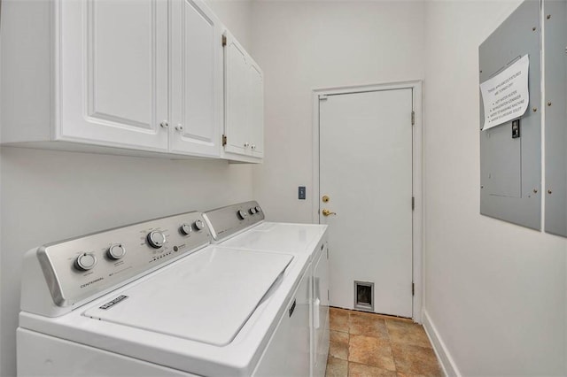 laundry room featuring washing machine and clothes dryer, electric panel, and cabinets