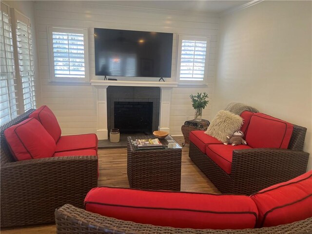 living room with light hardwood / wood-style flooring, ornamental molding, and ceiling fan