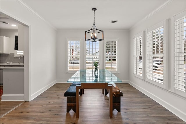 dining area featuring ornamental molding, dark hardwood / wood-style floors, and a notable chandelier