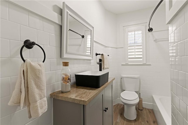 full bathroom with shower / tub combination, vanity, toilet, and hardwood / wood-style floors