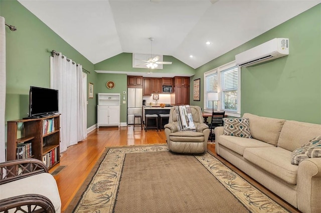 living room with a wall unit AC, baseboards, ceiling fan, vaulted ceiling, and light wood-style floors