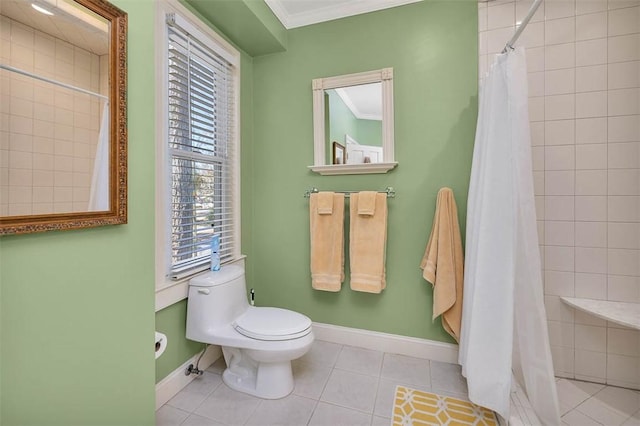 bathroom with tile patterned flooring, a tile shower, toilet, and crown molding