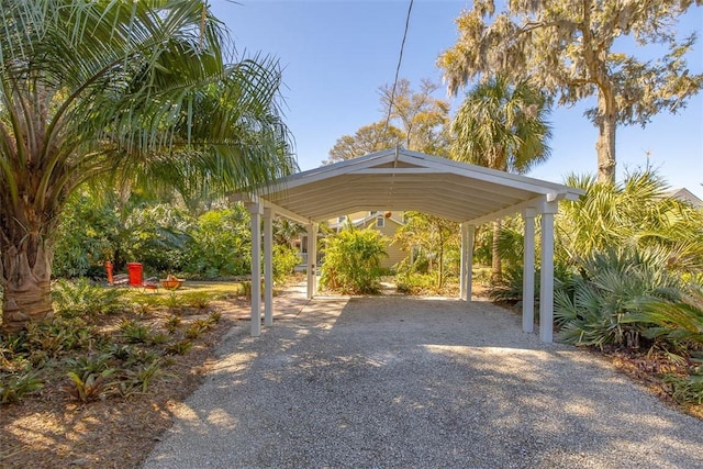 view of vehicle parking with gravel driveway and a detached carport