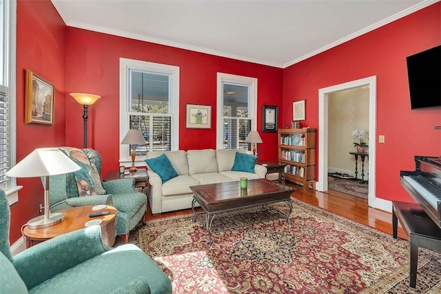 living area featuring wood finished floors, baseboards, and ornamental molding