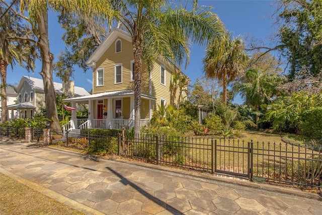 view of front of home featuring covered porch and a fenced front yard