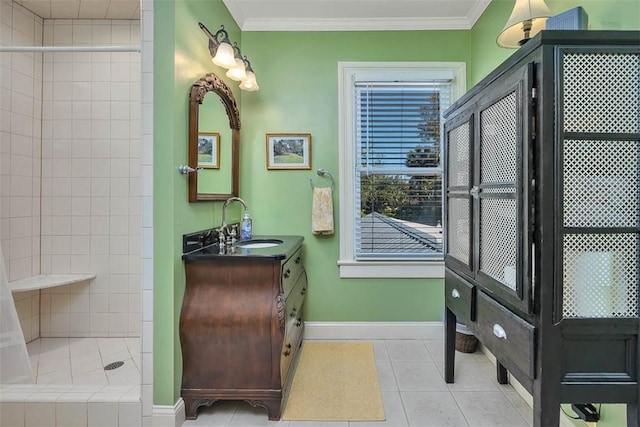 full bath with tile patterned floors, a tile shower, crown molding, baseboards, and vanity