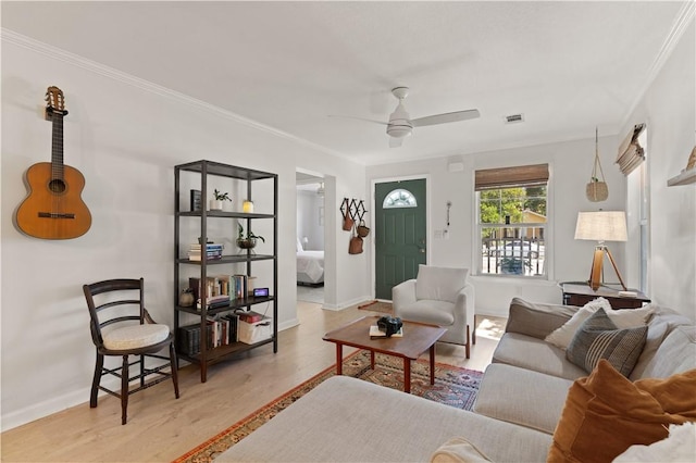 living room featuring light wood-type flooring, ceiling fan, and ornamental molding