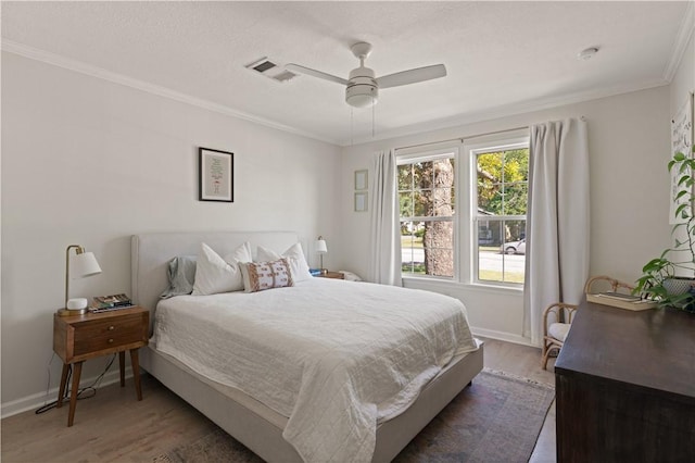 bedroom featuring dark hardwood / wood-style floors, ceiling fan, and crown molding