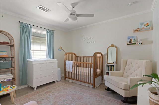 bedroom with ceiling fan, crown molding, and a crib