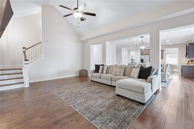 living room featuring ceiling fan with notable chandelier, dark hardwood / wood-style floors, and high vaulted ceiling