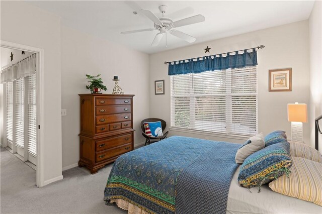 bedroom with access to exterior, ceiling fan, and light carpet