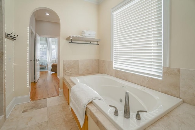 bathroom featuring ornamental molding and a tub