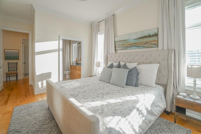 bedroom with ensuite bath, crown molding, and light wood-type flooring