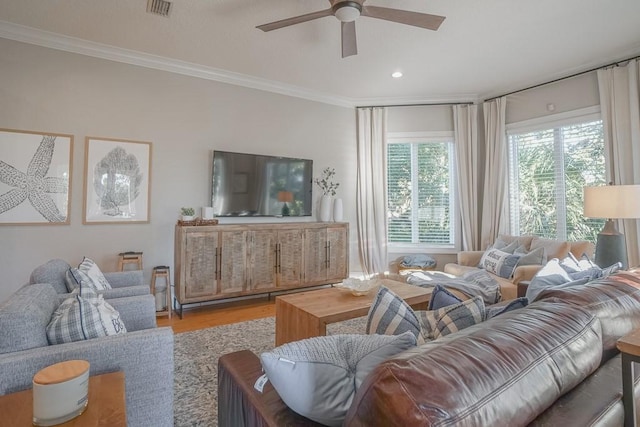 living room with ceiling fan, light wood-type flooring, and ornamental molding