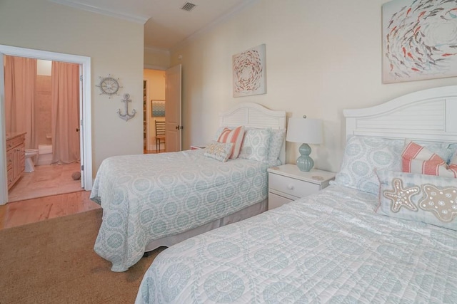 carpeted bedroom featuring ensuite bathroom and ornamental molding