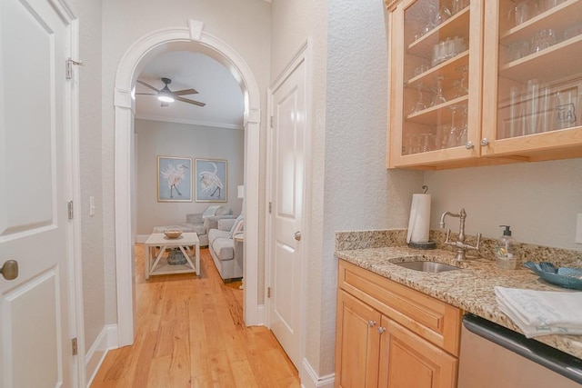 bar featuring ornamental molding, ceiling fan, sink, dishwasher, and light hardwood / wood-style floors