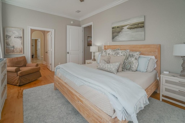 bedroom featuring light hardwood / wood-style floors and crown molding