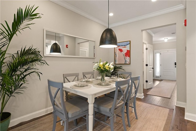 dining space with hardwood / wood-style floors and crown molding