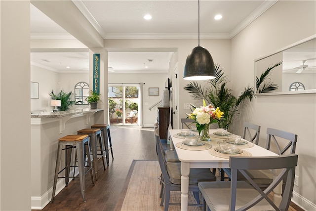 dining area featuring dark hardwood / wood-style flooring, ceiling fan, and crown molding