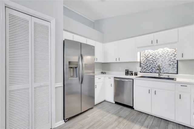 kitchen with white cabinets, stainless steel appliances, light hardwood / wood-style flooring, and sink