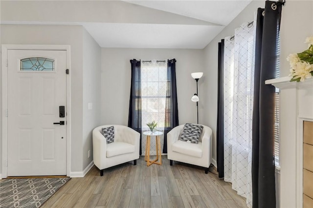 entryway with light wood-type flooring and vaulted ceiling