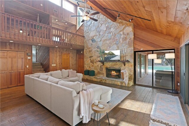 living room with wood walls, hardwood / wood-style floors, and high vaulted ceiling