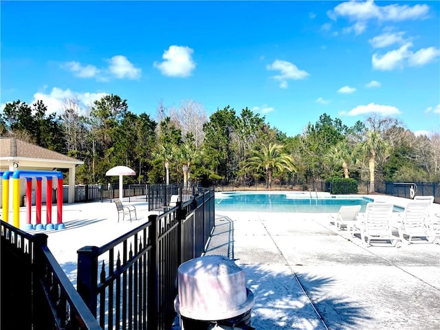 view of swimming pool featuring grilling area and a patio